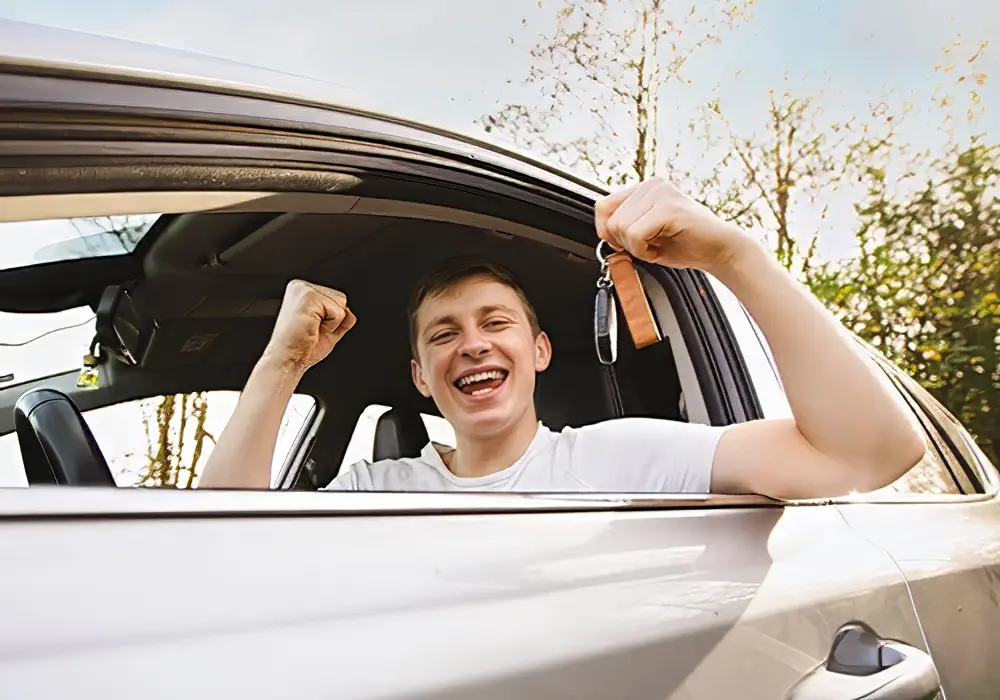 Un jeune conducteur au volant de sa voiture neuve