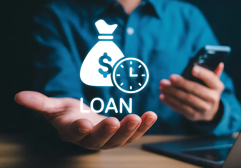 Un homme tient le mot 'loan' devant son ordinateur